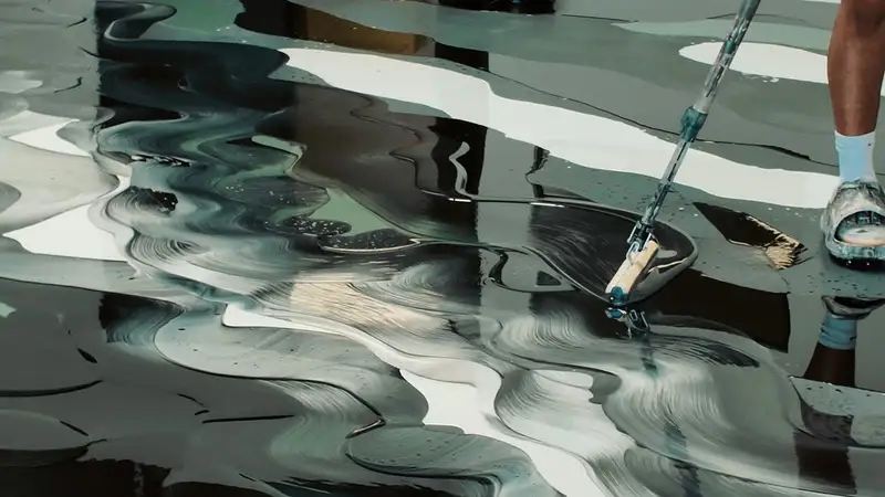 Metallic epoxy being poured and worked into a floor